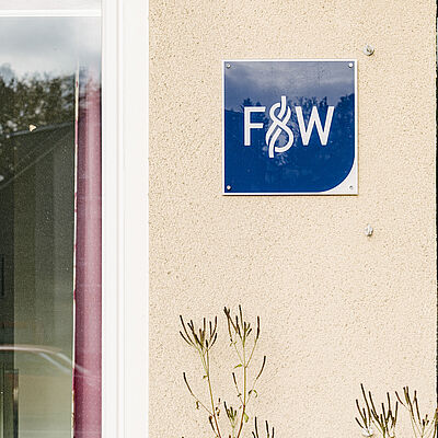 Das Logo von F&W an einer Hauswand 