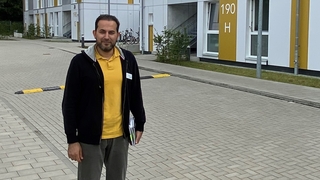 Der Mitarbeiter vor einer Unterkunft