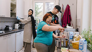 Eine Mitarbeiterin von F&W kocht mit Bewohner:innen