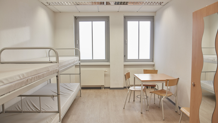 Zimmer mit Betten, Tisch und Schrank