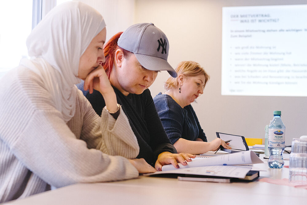 Bewohner:innen am Tisch bei einer Veranstaltung für den Mieterführerschein Bewohner:innen am Tisch bei einer Veranstaltung für den Mieterführerschein