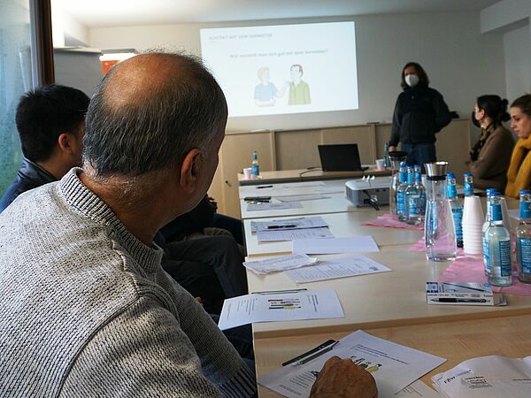 Bewohner:innen am Tisch bei einer Veranstaltung für den Mieterführerschein.