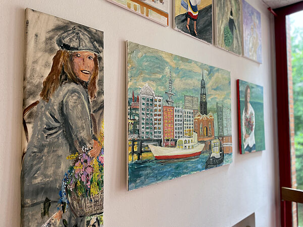 Gemälde des Bewohners hängen nebeneinander an der Wand