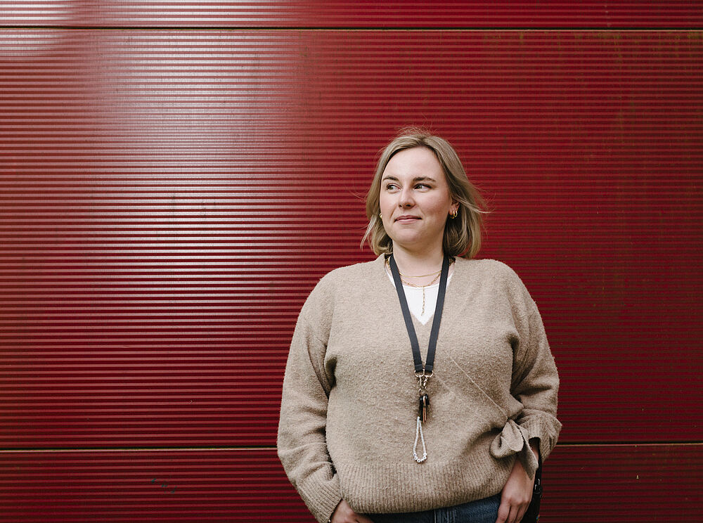 Annalena steht vor der roten Containerwand.