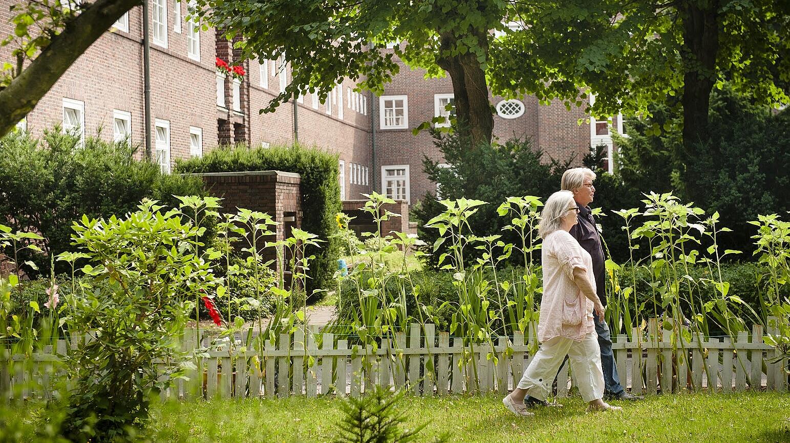 Zwei Personen gehen im Garten spazieren