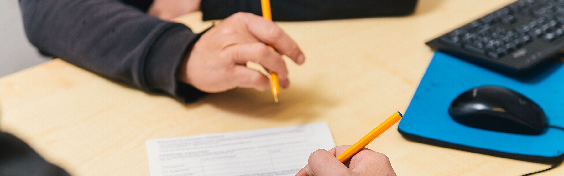 Hände über ein Dokument gebeugt 