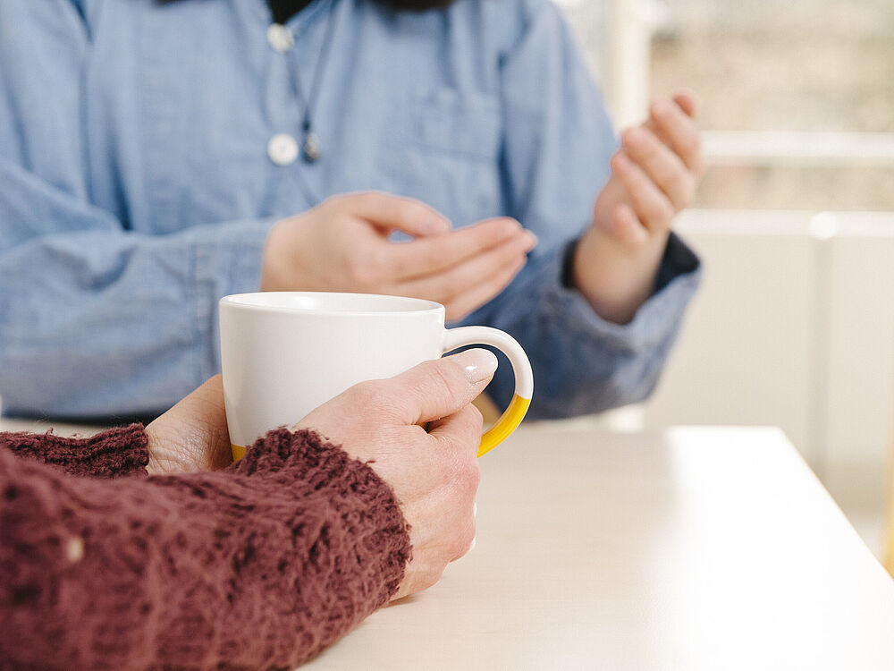 Eine Hand mit einer Tasse