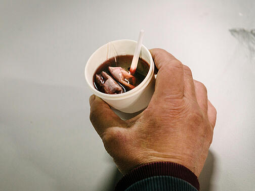 Auf dem Bild sieht man eine Hand mit einem Becher Tee.