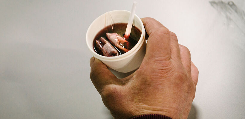 Eine Tasse Tee in einer Hand
