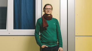 David steht vor einer gelben Wand.