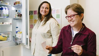 Eine Klientin und eine Mitarbeiterin am Kühlschrank