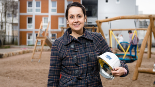 Eine Frau mit einem Bauhelm unterm Arm