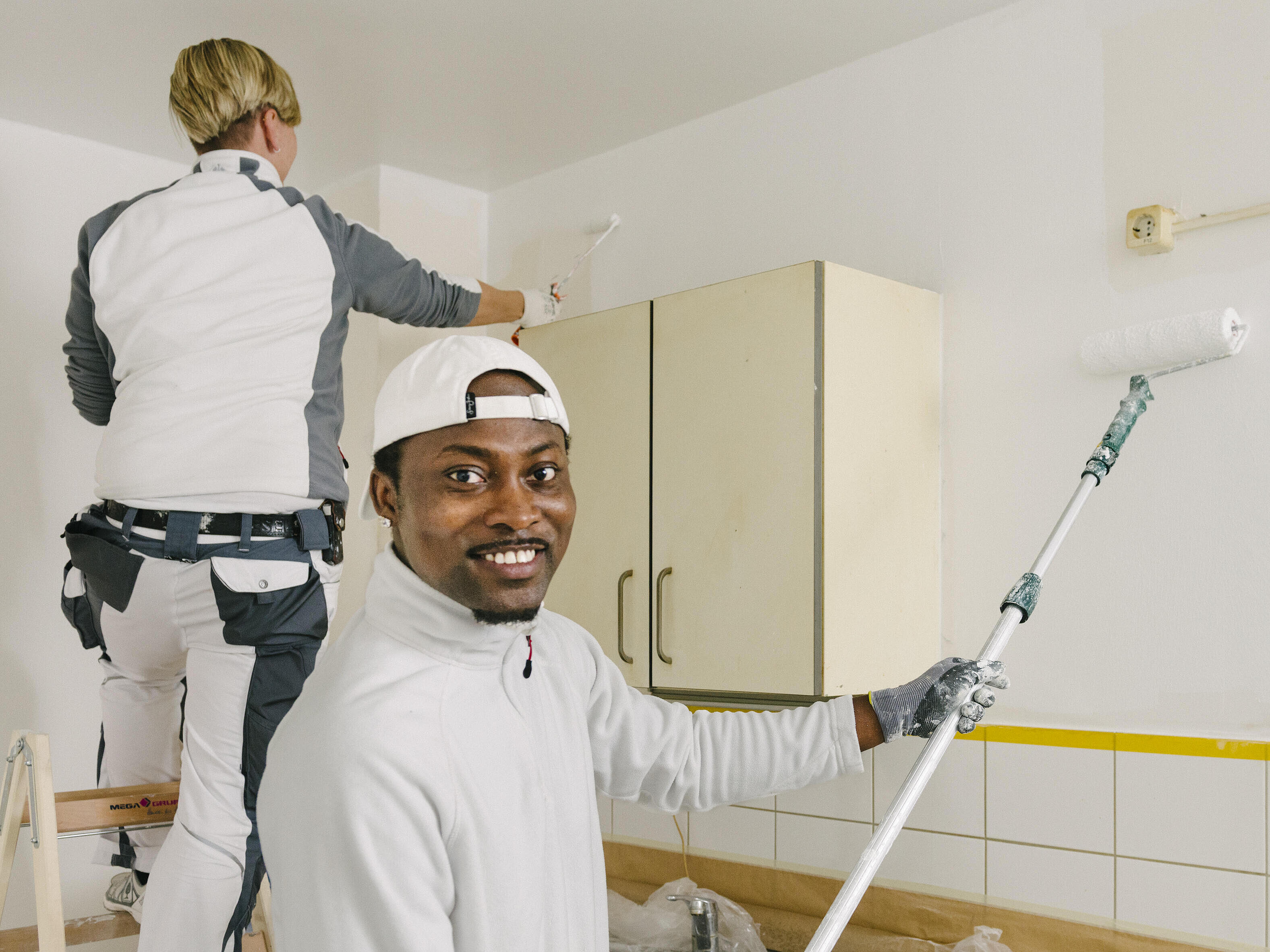 Ein junger Mann malert eine Wand an