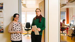 Zwei Kollegen stehen an einer Bürotür