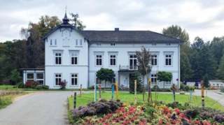 Das Haus in Sachsenwaldau ist weiß und steht frei vor einem Kreisel.