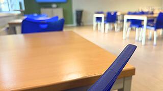 Blick über eine blaue Stuhllehne in den Aufenthaltsraum