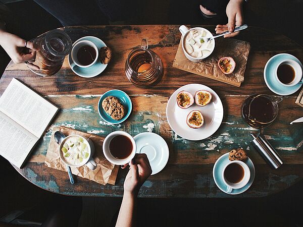 Kaffee, Tee, Gebäck und Früchte auf Tisch 