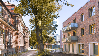 Ein altes Haus auf der linken, ein Neubau auf der rechten Seite.