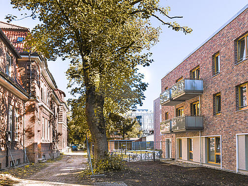 Ein altes Haus auf der linken, ein Neubau auf der rechten Seite. 