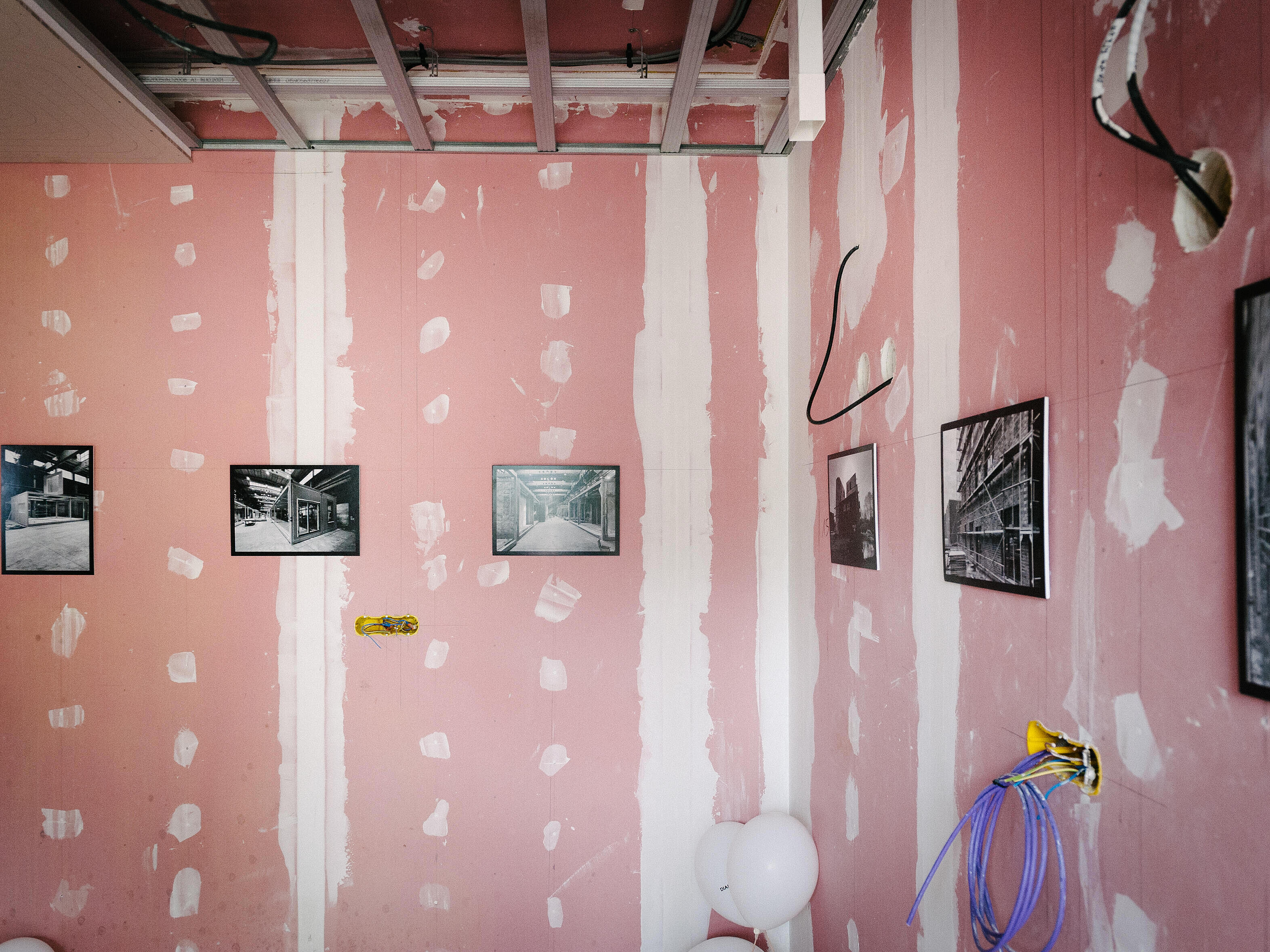 Bilder an einer halb verputzten Wand