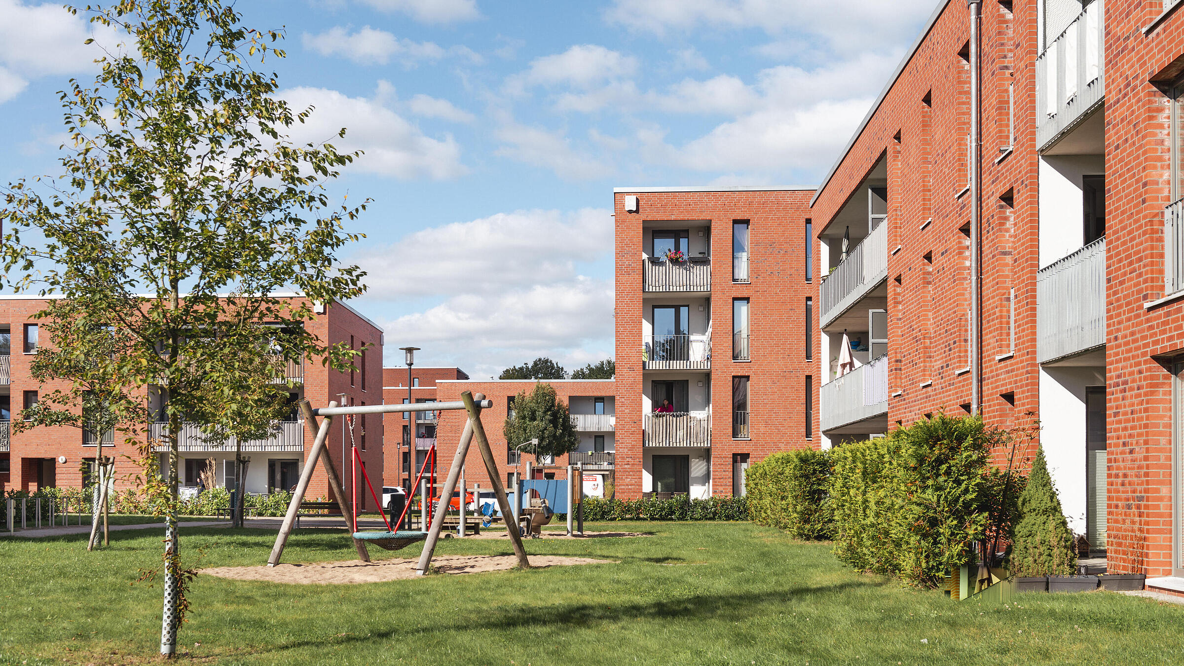Das Bild zeigt einen Spielplatz zwischen den Häusern.