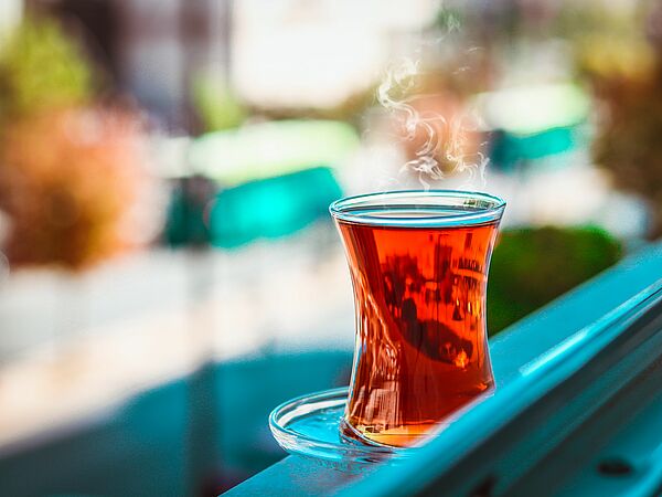 Dampfender Tee in Glas steht im Fenster