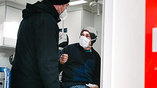 Ein Sozialarbeiter mit einer obdachlosen Person im Bus