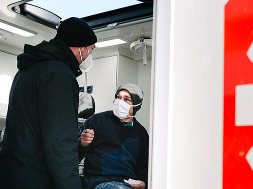 Ein Sozialarbeiter mit einer obdachlosen Person im Bus