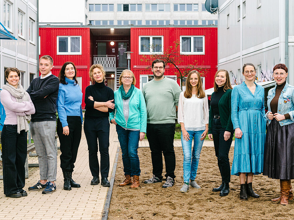 Gruppenfoto Team Freiwilligenkoordination im Innenhof einer Wohnunterkunft