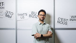 Der Kolleg steht vor einer weißen Wand mit Zetteln dran.