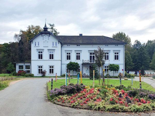 Das Haus in Sachsenwaldau ist weiß und steht frei vor einem Kreisel.