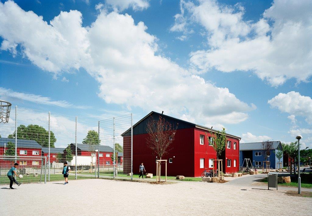 Die dunkelroten Modulhäuser der Unterkunft 